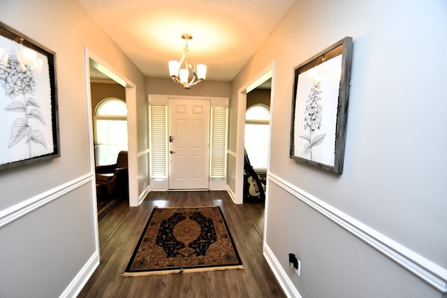 entryway with an inviting chandelier, wood finished floors, and baseboards