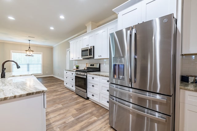 212 Archer Trl, Enterprise, AL 36330 - kitchen with stainless steel appliances, a sink, light wood-style floors, decorative backsplash, and crown molding