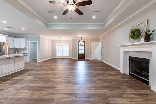 212 Archer Trl, Enterprise, AL 36330 - unfurnished living room featuring a brick fireplace, ceiling fan with notable chandelier, visible vents, and a raised ceiling