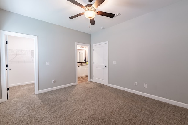 212 Archer Trl, Enterprise, AL 36330 - unfurnished bedroom with baseboards, light colored carpet, a ceiling fan, a closet, and a walk in closet