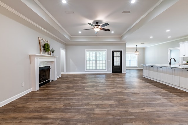 212 Archer Trl, Enterprise, AL 36330 - unfurnished living room with a tiled fireplace, dark wood-style flooring, a ceiling fan, and a raised ceiling
