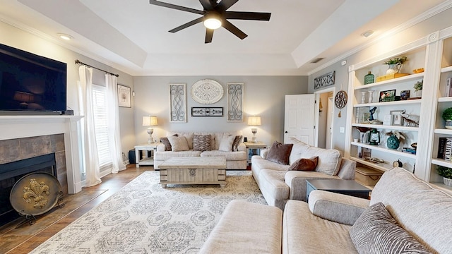 201 W Azalea Ln, Headland, AL 36345 - living room featuring a ceiling fan, a tray ceiling, a tile fireplace, built in features, and crown molding