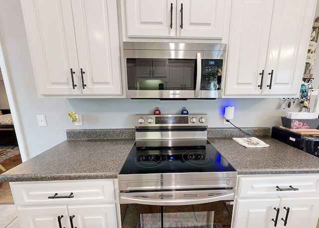 201 W Azalea Ln, Headland, AL 36345 - kitchen featuring appliances with stainless steel finishes, dark countertops, and white cabinetry