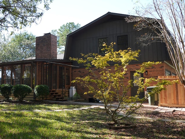 view of side of home featuring a sunroom and a yard