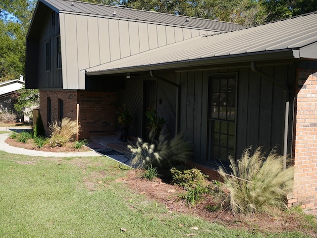 view of exterior entry featuring a lawn