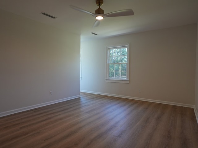 empty room with ceiling fan and dark hardwood / wood-style floors