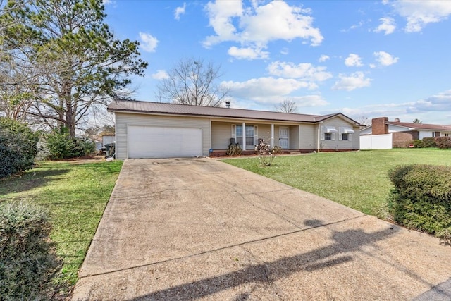 ranch-style house featuring an attached garage, metal roof, a front lawn, and concrete driveway