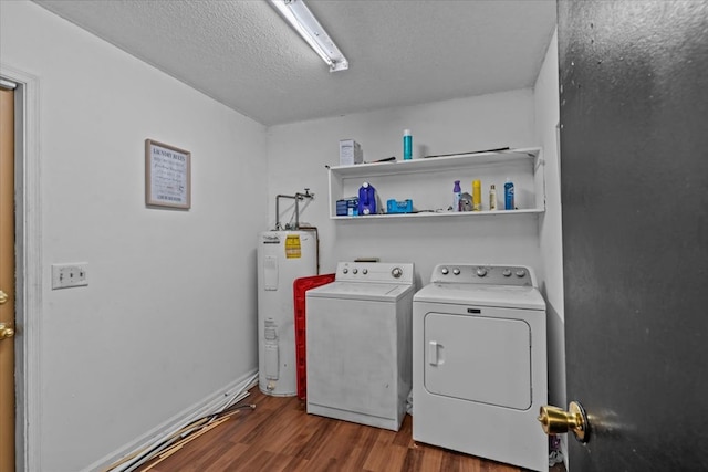 laundry room with dark wood-style flooring, water heater, washing machine and dryer, a textured ceiling, and laundry area