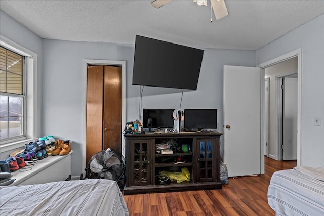 bedroom with a textured ceiling, ceiling fan, and wood finished floors