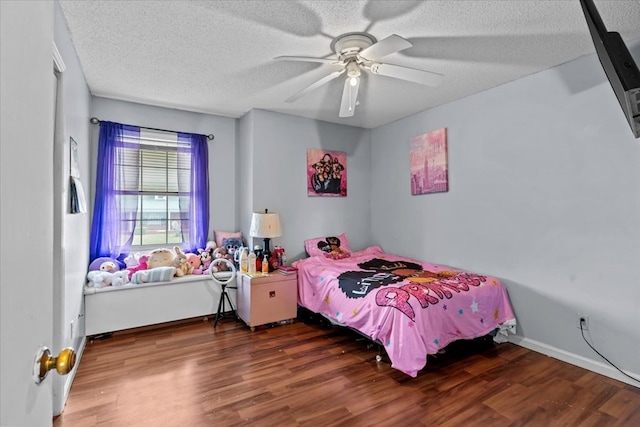 bedroom featuring a textured ceiling, ceiling fan, wood finished floors, and baseboards