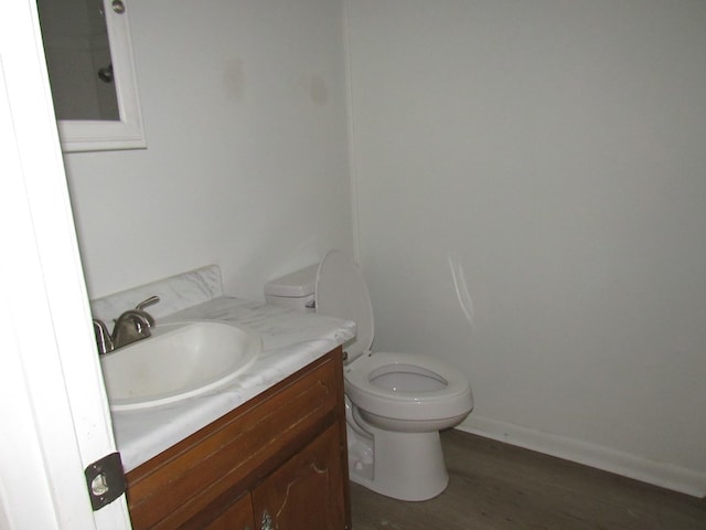 bathroom with hardwood / wood-style floors, vanity, and toilet