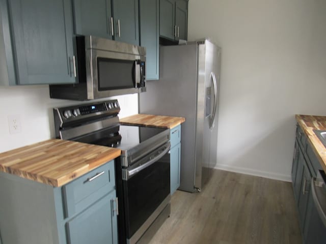 kitchen featuring butcher block counters, light hardwood / wood-style floors, and appliances with stainless steel finishes