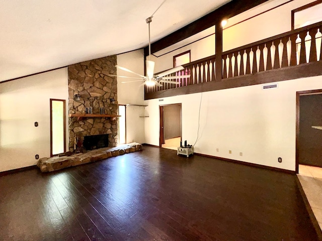 unfurnished living room with hardwood / wood-style floors, high vaulted ceiling, ceiling fan, a fireplace, and beamed ceiling