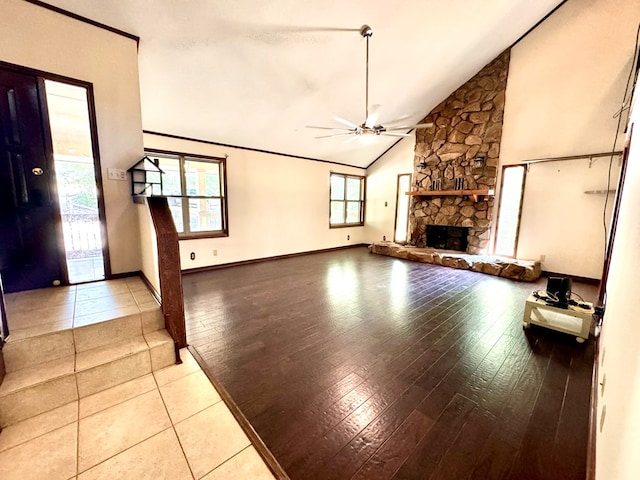 unfurnished living room featuring ceiling fan, a fireplace, lofted ceiling, and light wood-type flooring