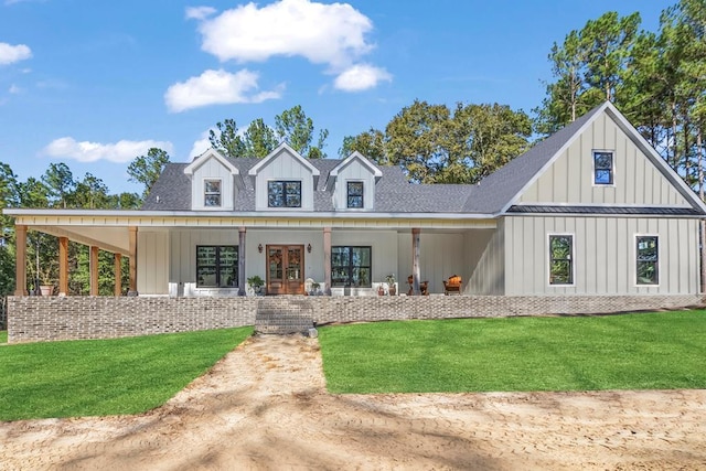 modern farmhouse style home with french doors, board and batten siding, a front yard, and a shingled roof