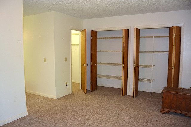 790 Claxton Ave, Elba, AL 36323 - unfurnished bedroom featuring a textured ceiling, carpet floors, and multiple closets