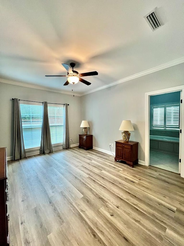 interior space featuring light wood-type flooring, ensuite bathroom, ceiling fan, and crown molding