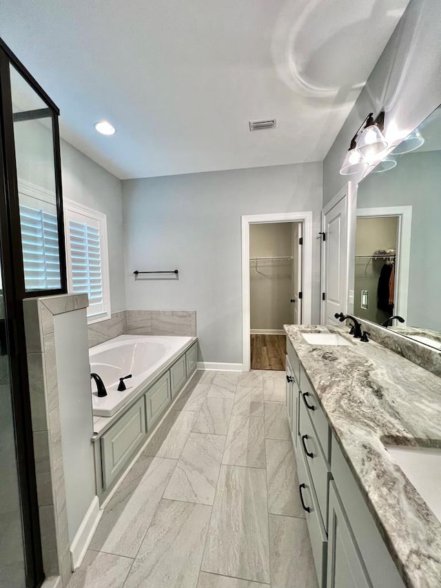 bathroom featuring a washtub and vanity