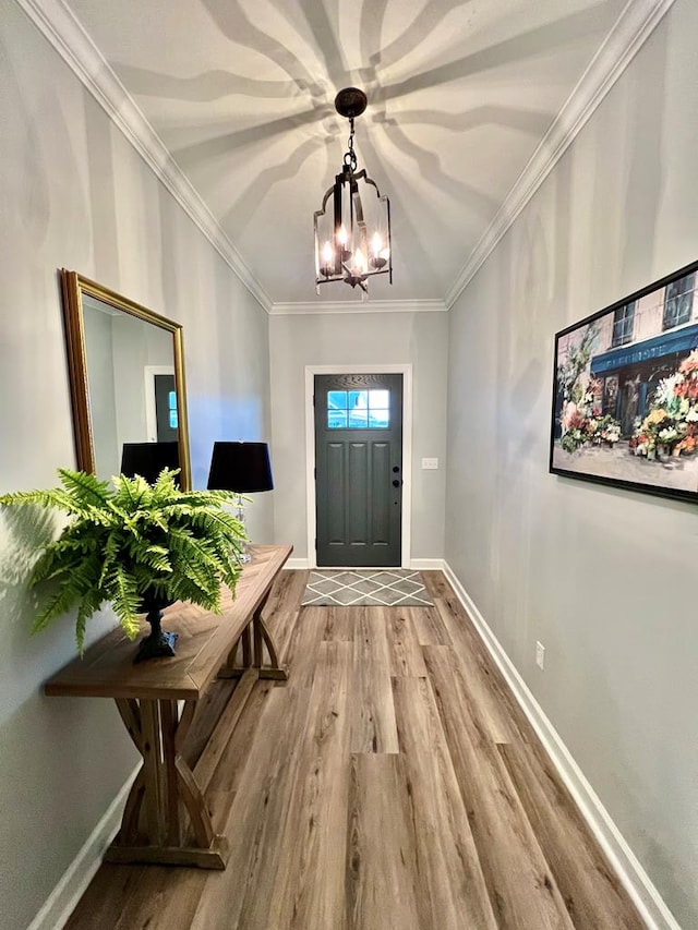 doorway to outside with a chandelier, crown molding, and wood-type flooring