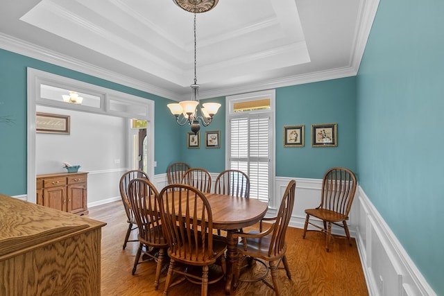 400 Bent Oak Dr, Dothan, AL 36303 - dining area featuring light wood-type flooring, a raised ceiling, a chandelier, ornamental molding, and wainscoting
