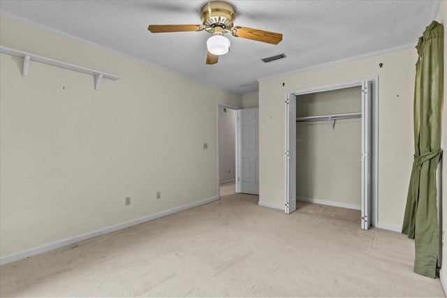 unfurnished bedroom featuring a textured ceiling, light colored carpet, ceiling fan, and crown molding