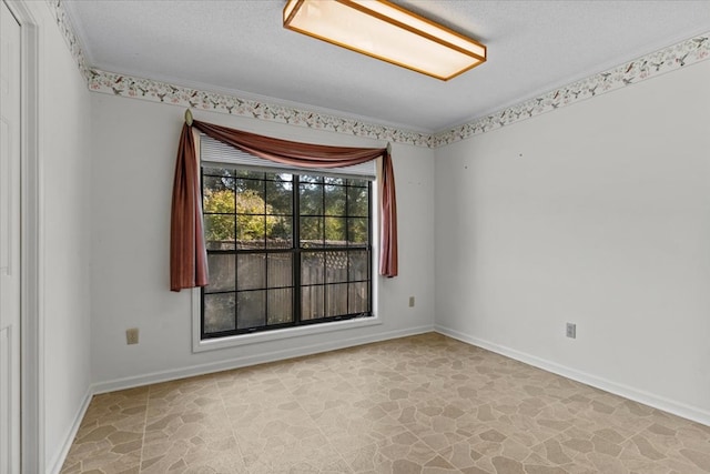 spare room featuring crown molding and a textured ceiling