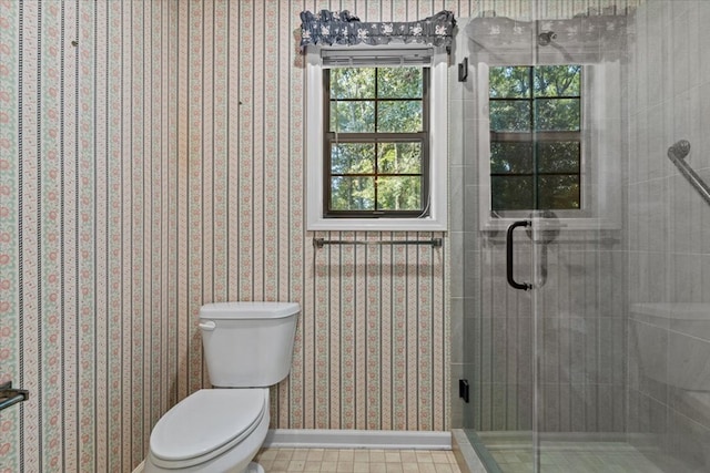 bathroom with tile patterned floors, a shower with door, and toilet