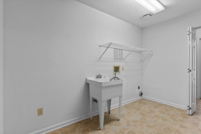 laundry room featuring hookup for an electric dryer, hookup for a washing machine, and a textured ceiling