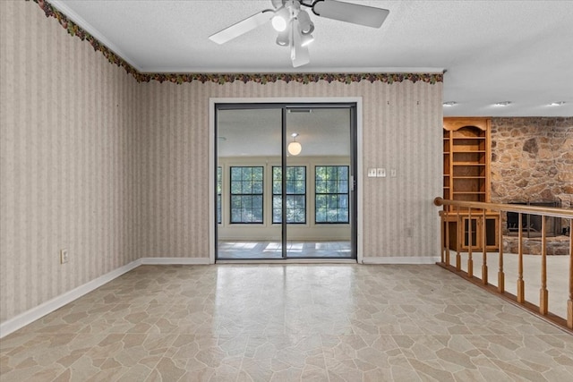 unfurnished room with built in shelves, ceiling fan, and a textured ceiling