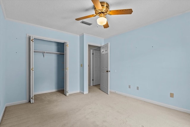 unfurnished bedroom featuring light carpet, a textured ceiling, ceiling fan, and crown molding