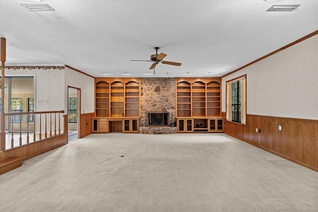 unfurnished living room with a fireplace, carpet, a textured ceiling, and ceiling fan