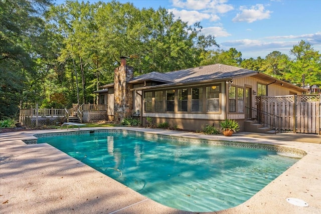 view of swimming pool with a sunroom and a deck