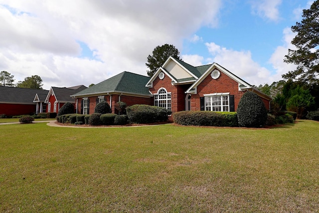 view of front facade with brick siding and a front lawn