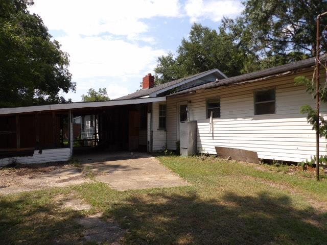 rear view of property with a yard and a carport