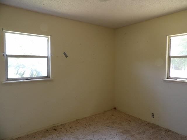 carpeted spare room with a textured ceiling