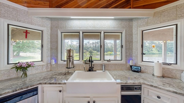 8875 E State Highway 52, Webb, AL 36376 - kitchen featuring a sink, healthy amount of natural light, white cabinets, wooden ceiling, and wallpapered walls
