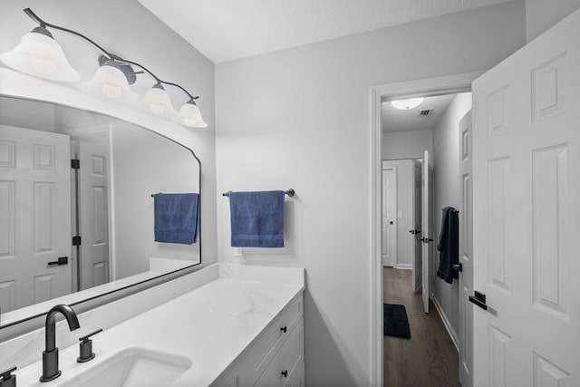 856 S County Rd 49, Dothan, AL 36301 - bathroom featuring wood finished floors, vanity, a textured ceiling, and baseboards