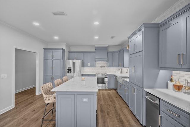 856 S County Rd 49, Dothan, AL 36301 - kitchen with stainless steel appliances, crown molding, a kitchen breakfast bar, a center island, and backsplash