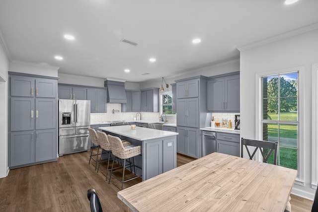 856 S County Rd 49, Dothan, AL 36301 - kitchen featuring appliances with stainless steel finishes, crown molding, premium range hood, a center island, and a breakfast bar