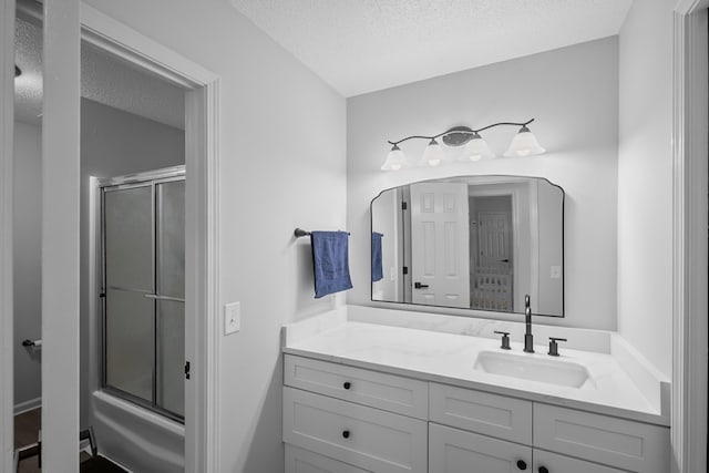 856 S County Rd 49, Dothan, AL 36301 - bathroom featuring a textured ceiling, vanity, and bath / shower combo with glass door