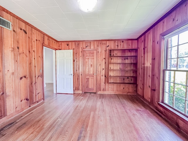 800 W Brookside Ave, Geneva, AL 36340 - empty room featuring wood walls, healthy amount of natural light, and light wood-style flooring