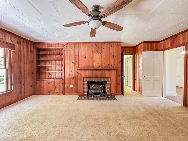 800 W Brookside Ave, Geneva, AL 36340 - unfurnished living room with wooden walls, a ceiling fan, built in features, carpet, and a brick fireplace