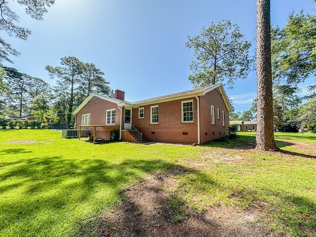 800 W Brookside Ave, Geneva, AL 36340 - rear view of house with brick siding, a chimney, crawl space, and a lawn
