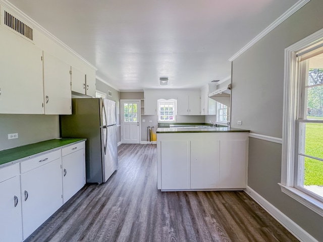 800 W Brookside Ave, Geneva, AL 36340 - kitchen with dark wood-type flooring, white cabinetry, a peninsula, and freestanding refrigerator