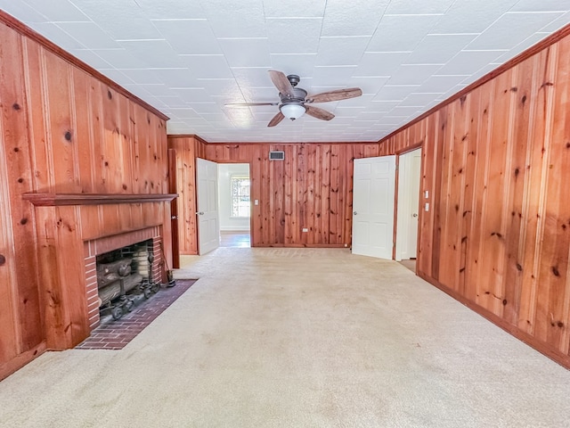 800 W Brookside Ave, Geneva, AL 36340 - unfurnished living room with wooden walls, carpet, a fireplace, a ceiling fan, and ornamental molding