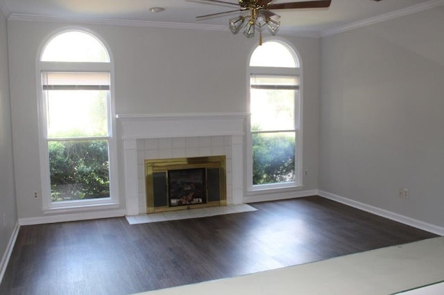 unfurnished living room with plenty of natural light, dark hardwood / wood-style floors, and a tiled fireplace