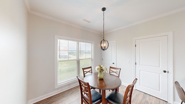 dining space featuring light hardwood / wood-style flooring and ornamental molding