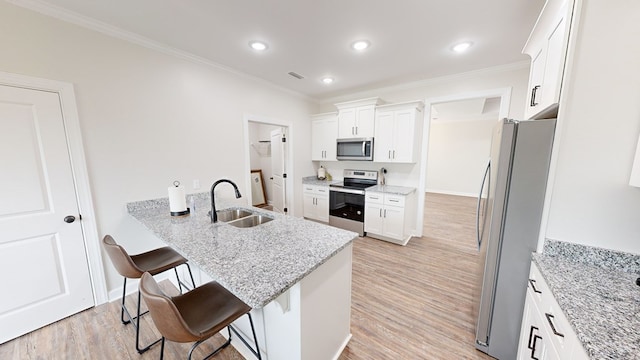 kitchen featuring sink, stainless steel appliances, light stone counters, a kitchen bar, and white cabinets