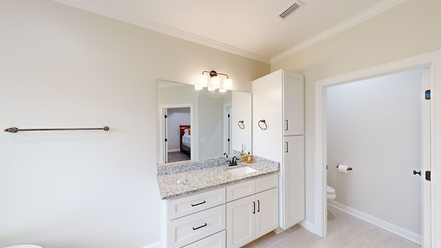 bathroom with vanity, toilet, and ornamental molding