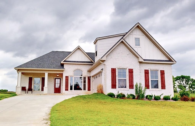 view of front of house featuring covered porch, a garage, and a front lawn